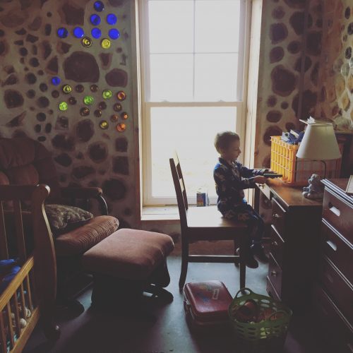 child at desk in cordwood house